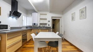A modern kitchen with wooden cabinets, a white dining table, and chairs. - Ginori C in Firenze With 3 Bedrooms and 2 Bathrooms (Florence)