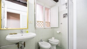 A bathroom with a sink, two toilets, a mirror, and a shower. - Ginori C in Firenze With 3 Bedrooms and 2 Bathrooms (Florence)