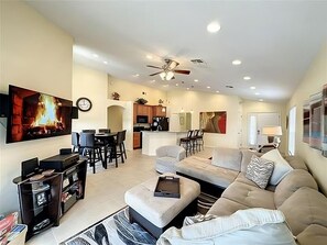 Relax in this spacious living area with a large sofa, flat-screen TV, and cozy fireplace.