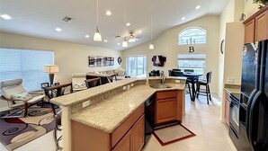 A spacious kitchen with a large island, modern appliances, and ample natural light from the windows.