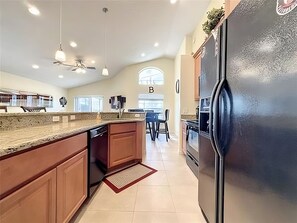 Enjoy cooking in this well-equipped kitchen with a central island, oven, and granite countertop.