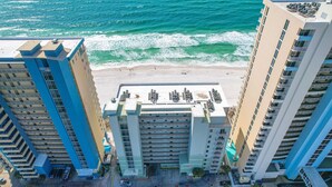 Un hotel de gran altura con estacionamiento, vista a la playa y varios pisos.