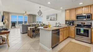 Una cocina moderna con una isla central, electrodomésticos de acero inoxidable y vistas al exterior.