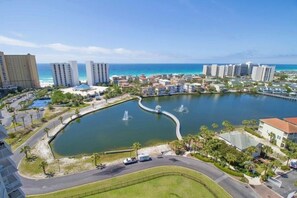 A coastal resort area with a large body of water, multiple buildings, and a curved road. - Terrace at Pelican Beach 1205 2 Bedroom Condo by Pelican Beach Management (Destin)