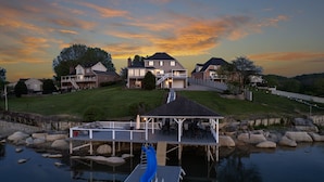 A residential area with houses, a dock, and a slide over water. - Boone Lake Haven with kayaks (Piney Flats)