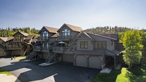 A large, multi-story residential building with a garage, a covered porch, and a staircase leading to a balcony. - The Oak Lane Chateau: with Private Hot Tub, Close to Golf, Free Ski Shuttle!! (Breckenridge)