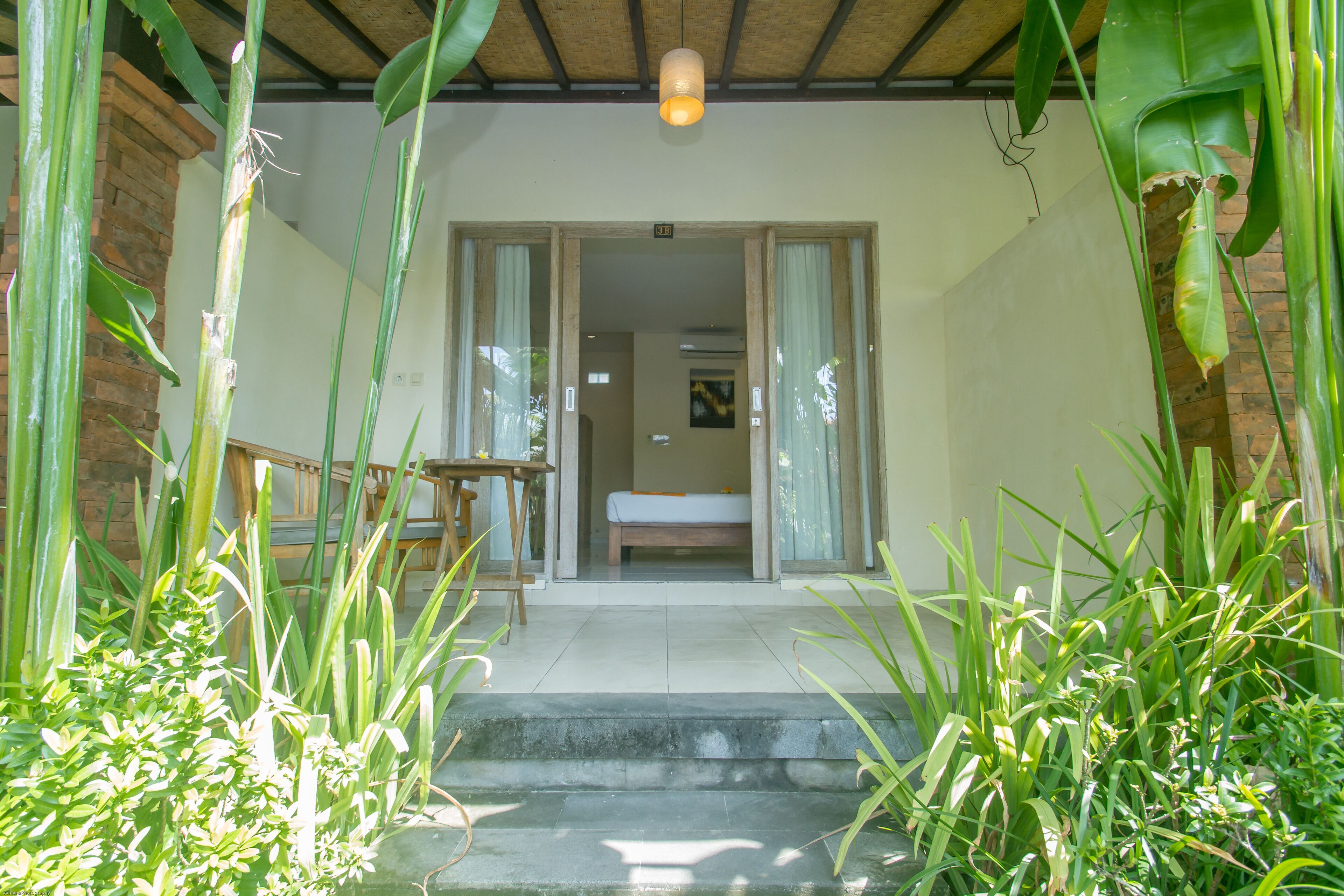 A room with a bed, a table, and chairs, and a staircase leading to the entrance.