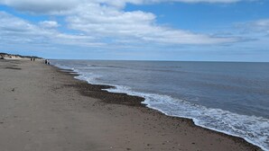 Een strand met een kiezelstrand en een heldere lucht.