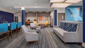 A modern hotel lobby with a seating area, a sofa, and a map mural on the wall. - Holiday Inn Express & Suites Courtenay - Comox by IHG (Courtenay)