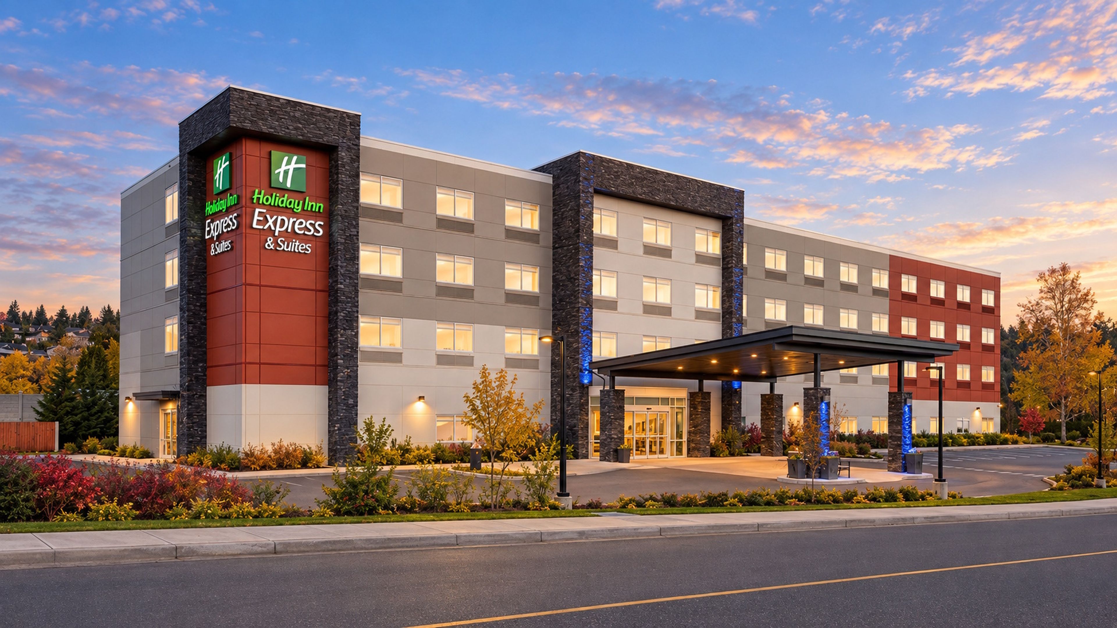 A Holiday Inn Express & Suites hotel with a modern facade, multiple windows, and a covered entrance.