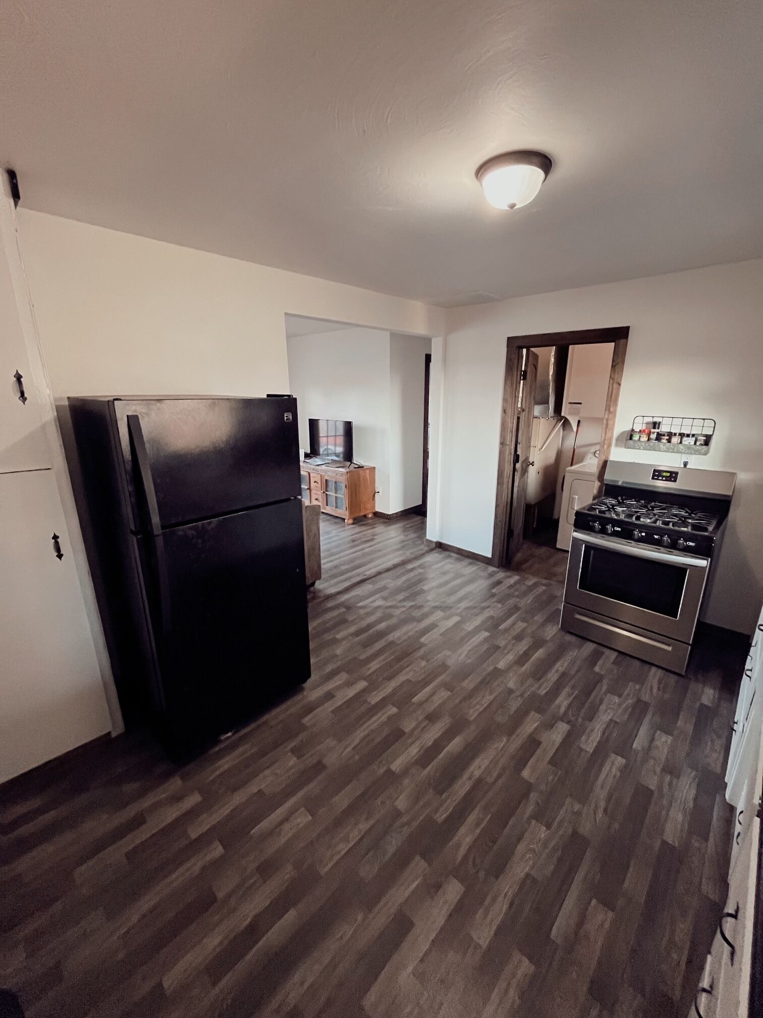 Una cocina con refrigerador, estufa y alacenas.