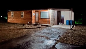 A small, single-story wooden cabin with a porch and a door leading to the interior. - Stockton Lakes’ Rustic Retreat - Cozy & Close (Stockton)