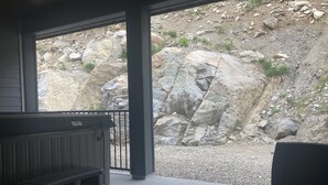 Un espace extérieur aménagé, abrité et doté d’un mur en pierre en arrière-plan.