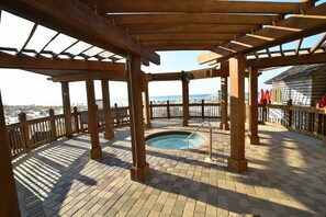 Relax in a serene hot tub surrounded by a wooden railing and enjoy the ocean views.