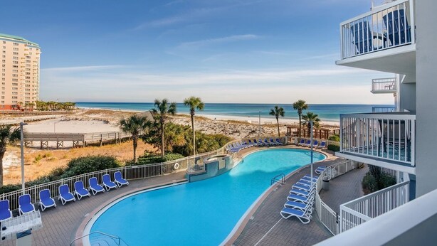 Ein Hotelpool mit Blick auf Strand und Meer.