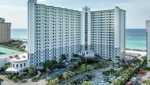 A high-rise hotel with multiple floors, a central tower, and a pool area. - Pelican Beach 1716 2 Bedroom Condo by Pelican Beach Management (Destin)