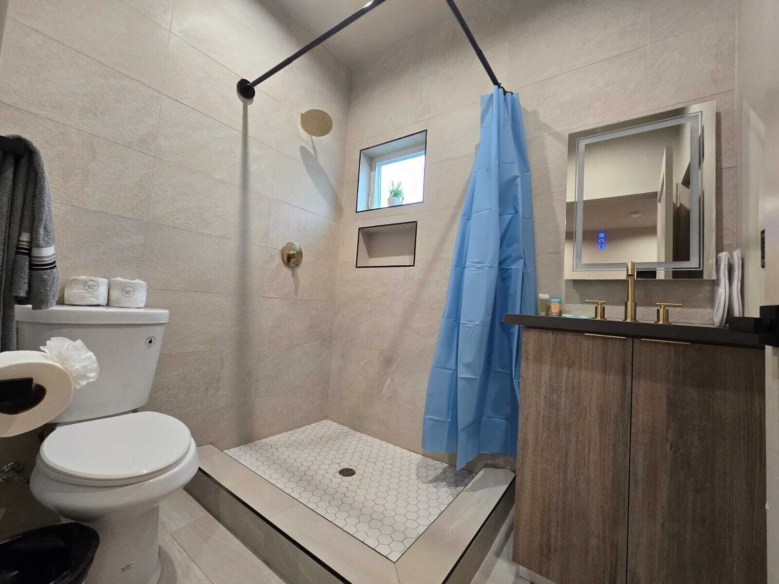 A bathroom with a shower, toilet, and sink.