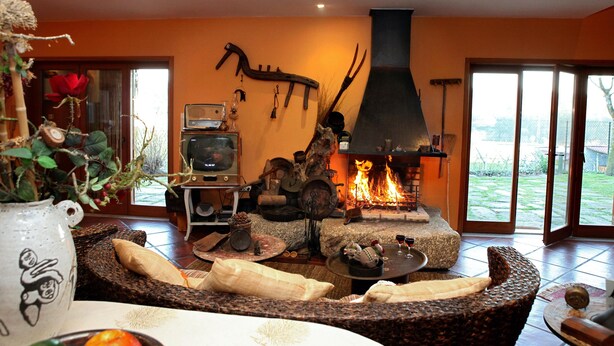 A cozy living room with a fireplace, comfortable seating, and a view of the outdoors.