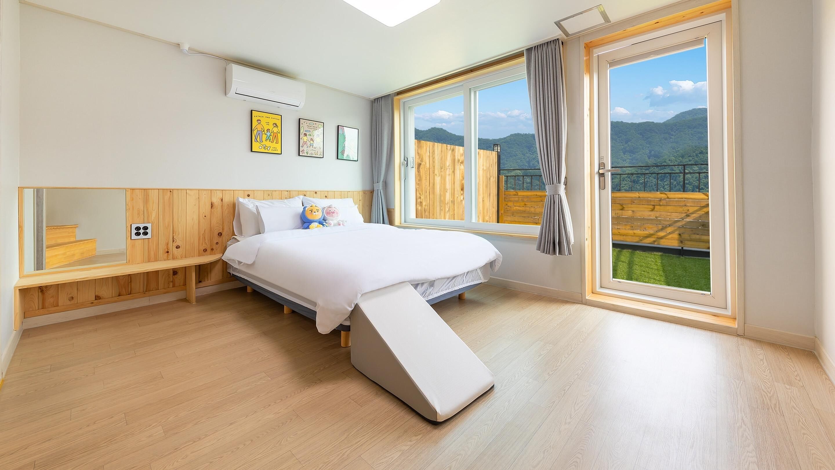 Un dormitorio con cama, una banca, una ventana con vistas y un ventilador de techo.