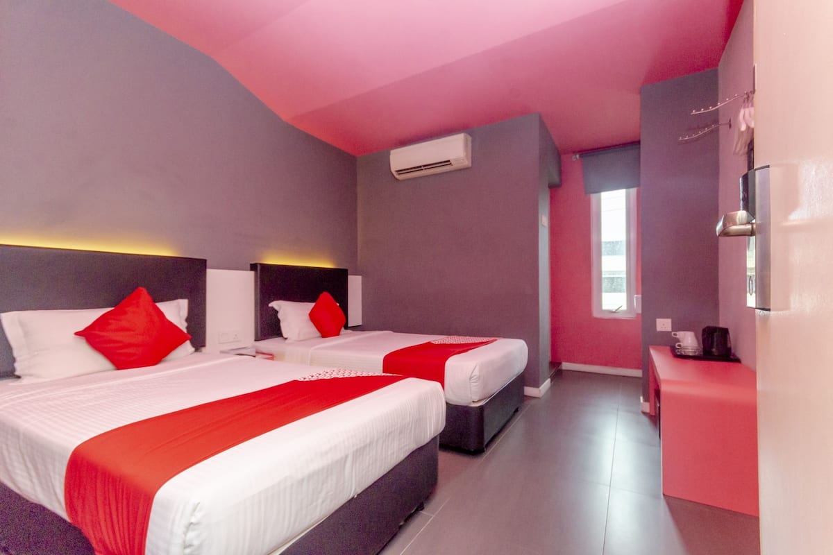 Une chambre d’hôtel avec deux lits, une petite kitchenette et une salle de bain.