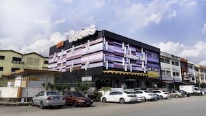 Een meerlaags gebouw met een bord dat een boetiekhotel aangeeft, een bioscoop en diverse winkels op de begane grond.