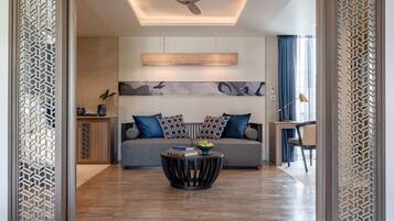 A modern living room with a sofa, a coffee table, and a ceiling fan.