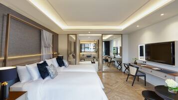 A modern hotel room with two beds, a desk, a TV, and a dining area.