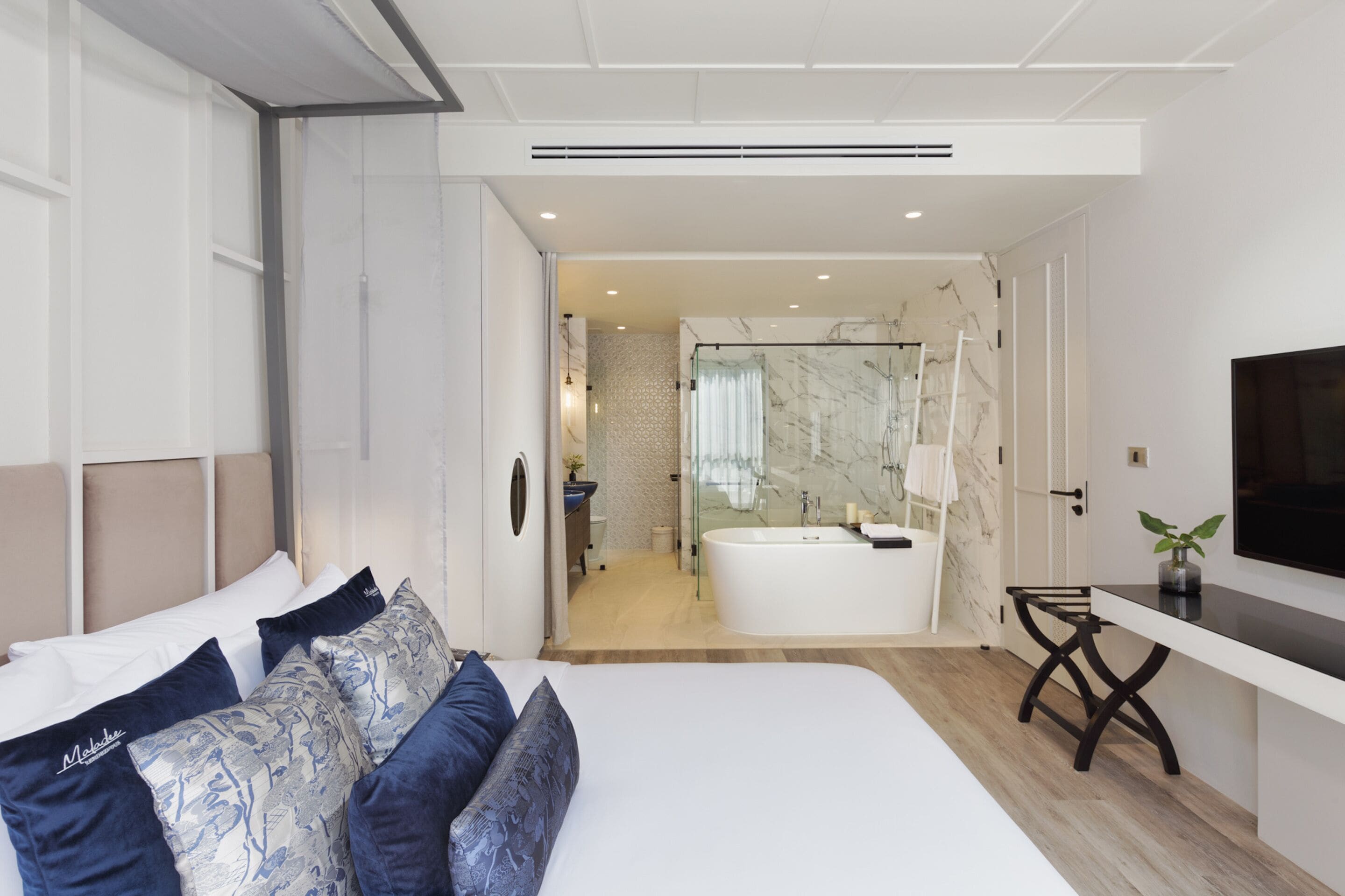 Een moderne hotelkamer met een groot bed, een bureau en een badkamer met een bad.