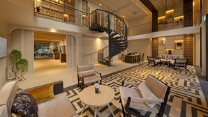 A spacious lobby with a central staircase, seating areas, and a dining space. - Maladee Rendezvous Hotel Chiang Mai (Chiang Mai)