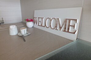 A reception area with a 'WELCOME' sign, a coffee station, and a vase with flowers. - Ferienohnung "silvija" / mit Balkon und Aussicht Aufs Meer (Novalja)