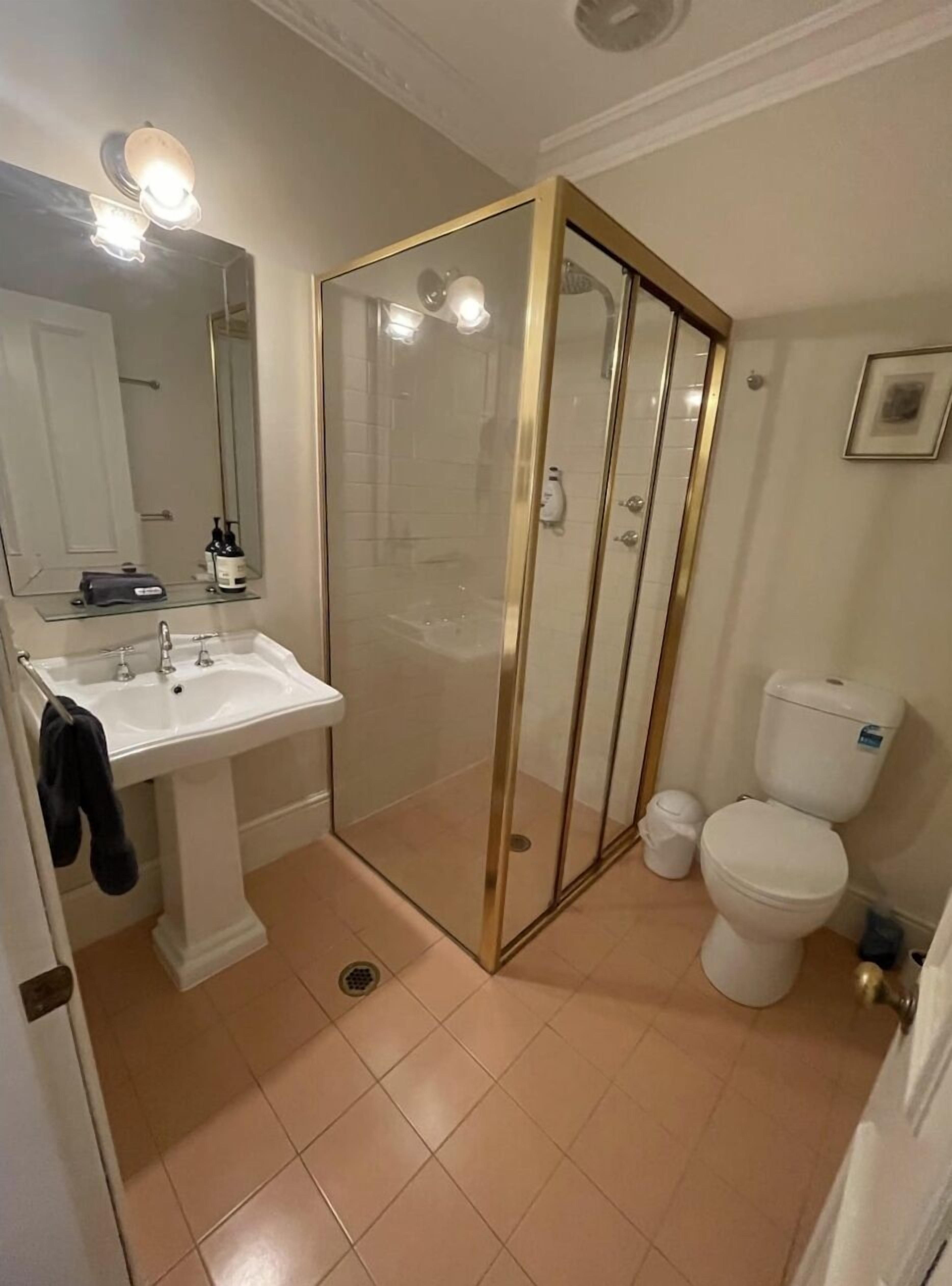 Un bagno con doccia vetrata, lavandino e water.