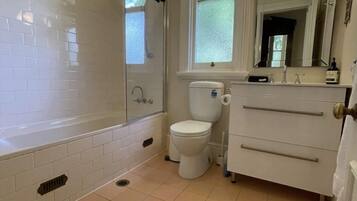 Un baño con bañera, inodoro y lavabo.