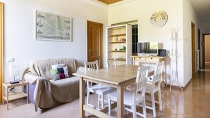 A living room with a sofa, a wooden dining table, and a TV. - Ruote for Three in Firenze (Florence)