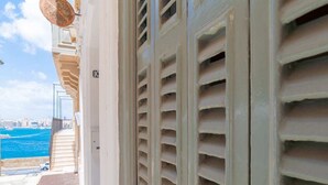 A balcony with a view of the sea and a cityscape. - Central Valletta Townhouse (Valletta)