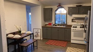 A kitchen with dark cabinets, a white stove, and a window above the sink. - Sunset views in the foothills (Rough and Ready)