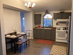 Kitchen area with central island, dining table, and window.