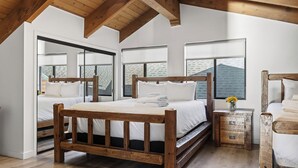 A bedroom with a wooden bed, a nightstand, and a window with a view of a brick building.
