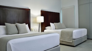 A hotel room with two beds, a nightstand with a lamp, and a wardrobe.