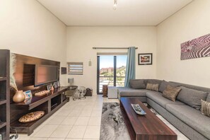 Departamento básico, varias camas | Área de sala de estar | Televisión 