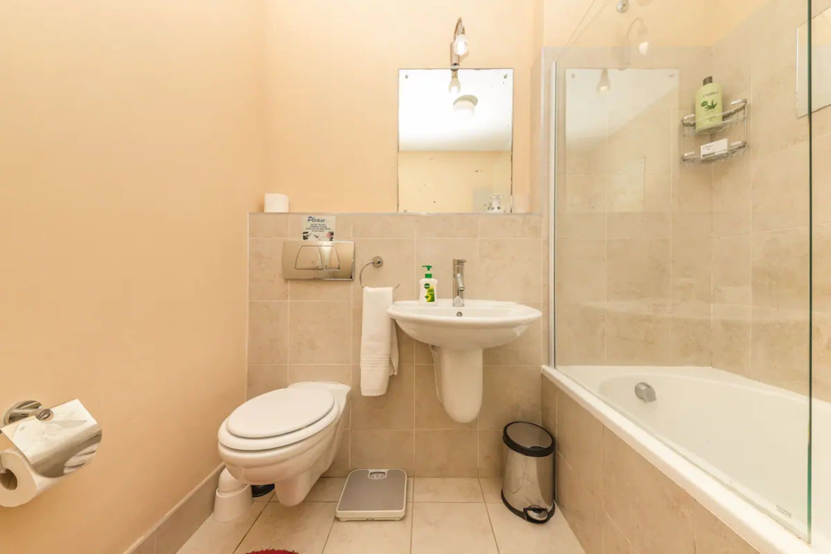 A bathroom with a toilet, sink, and bathtub.