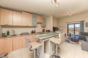 Departamento básico, varias camas | Cocina privada | Microondas, horno, parrilla de estufa y tetera eléctrica 