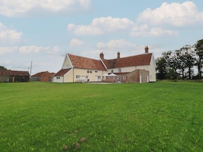 A large, single-story house with a sloped roof and a small porch area.