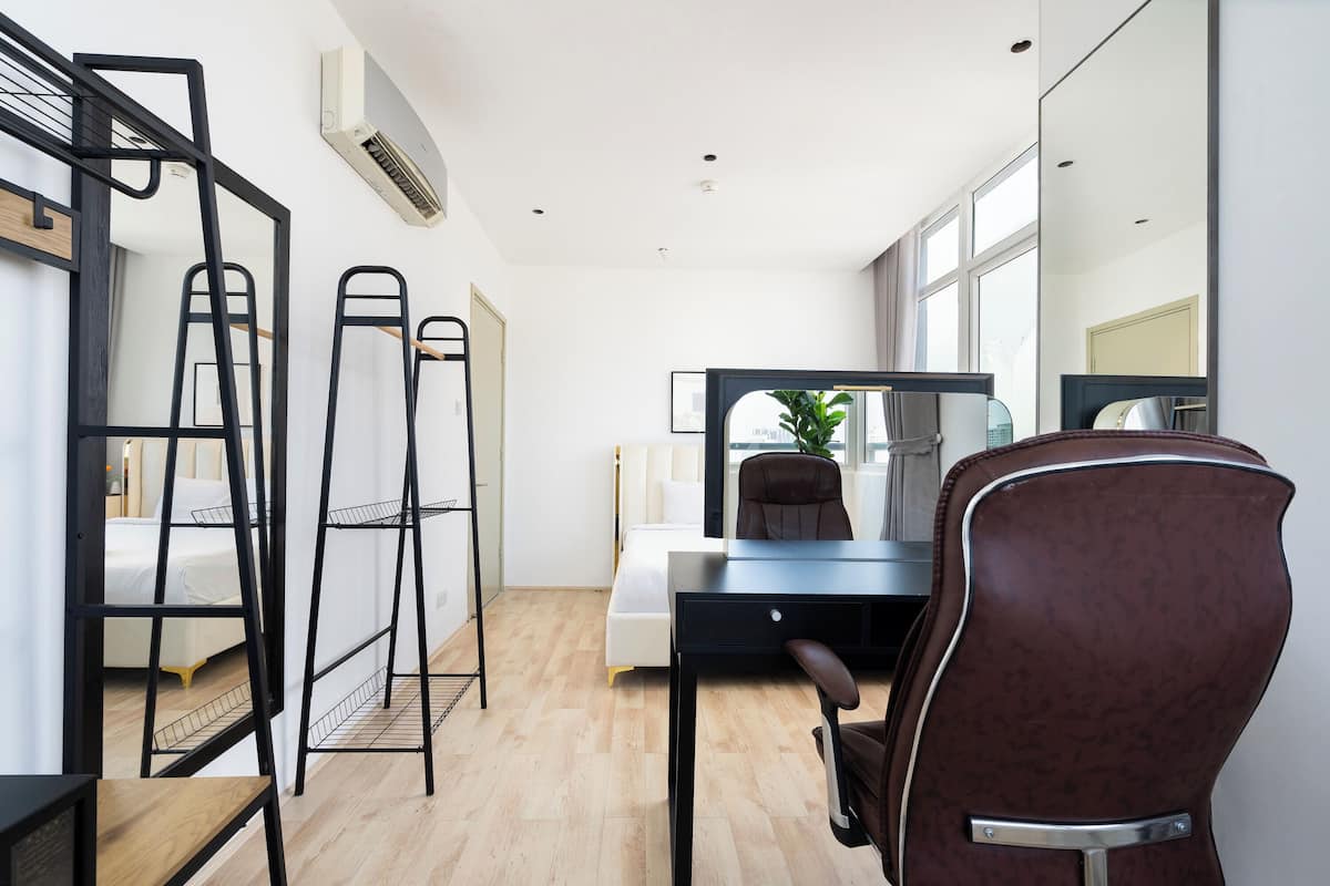 A modern hotel room with a desk, chair, and a bed.