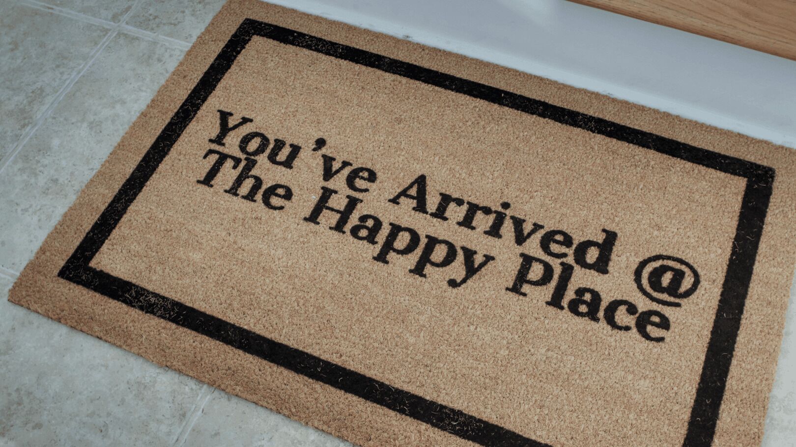Tapete de entrada com a frase "Chegou no The Happy Place".