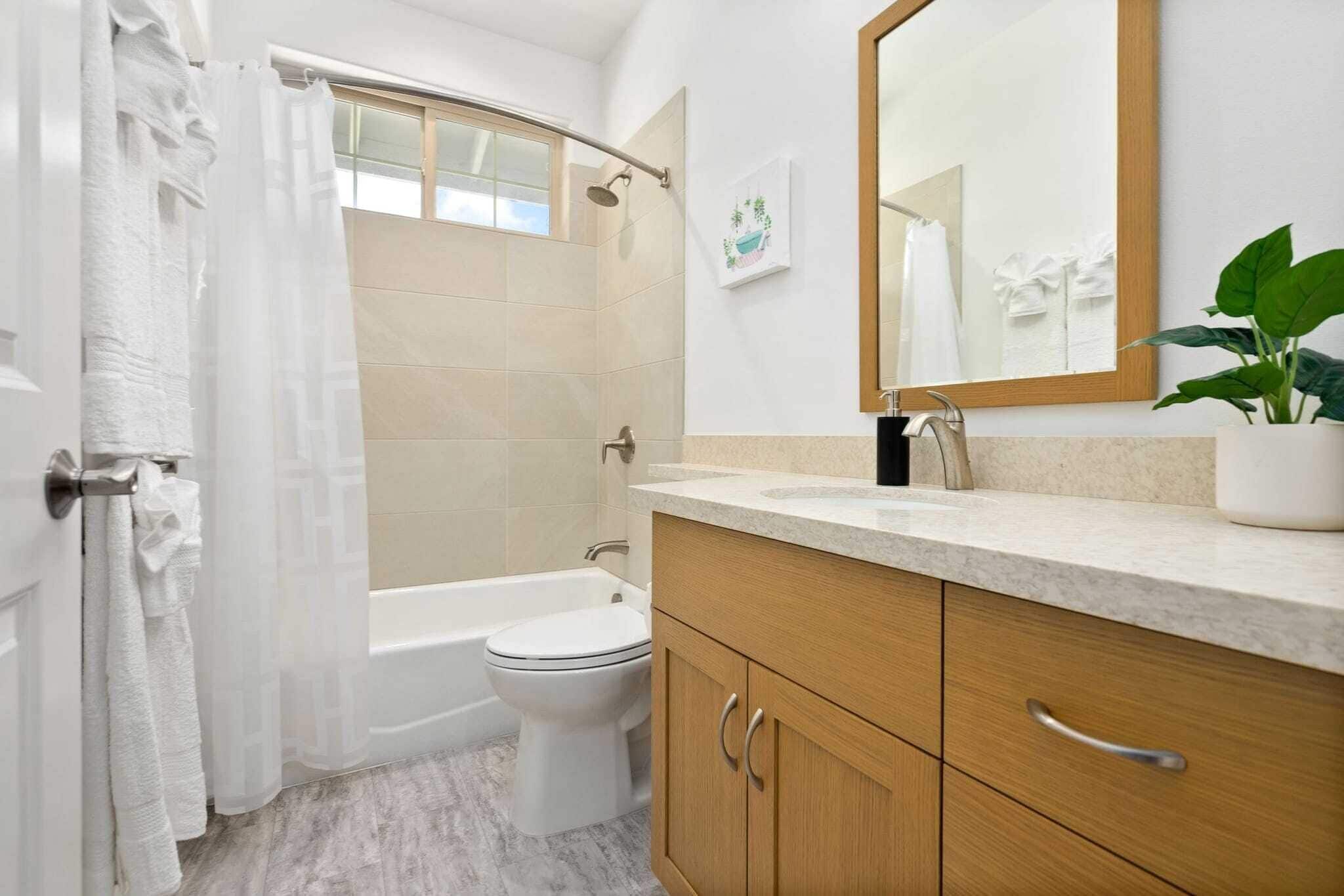 A modern bathroom with a bathtub, toilet, and sink.
