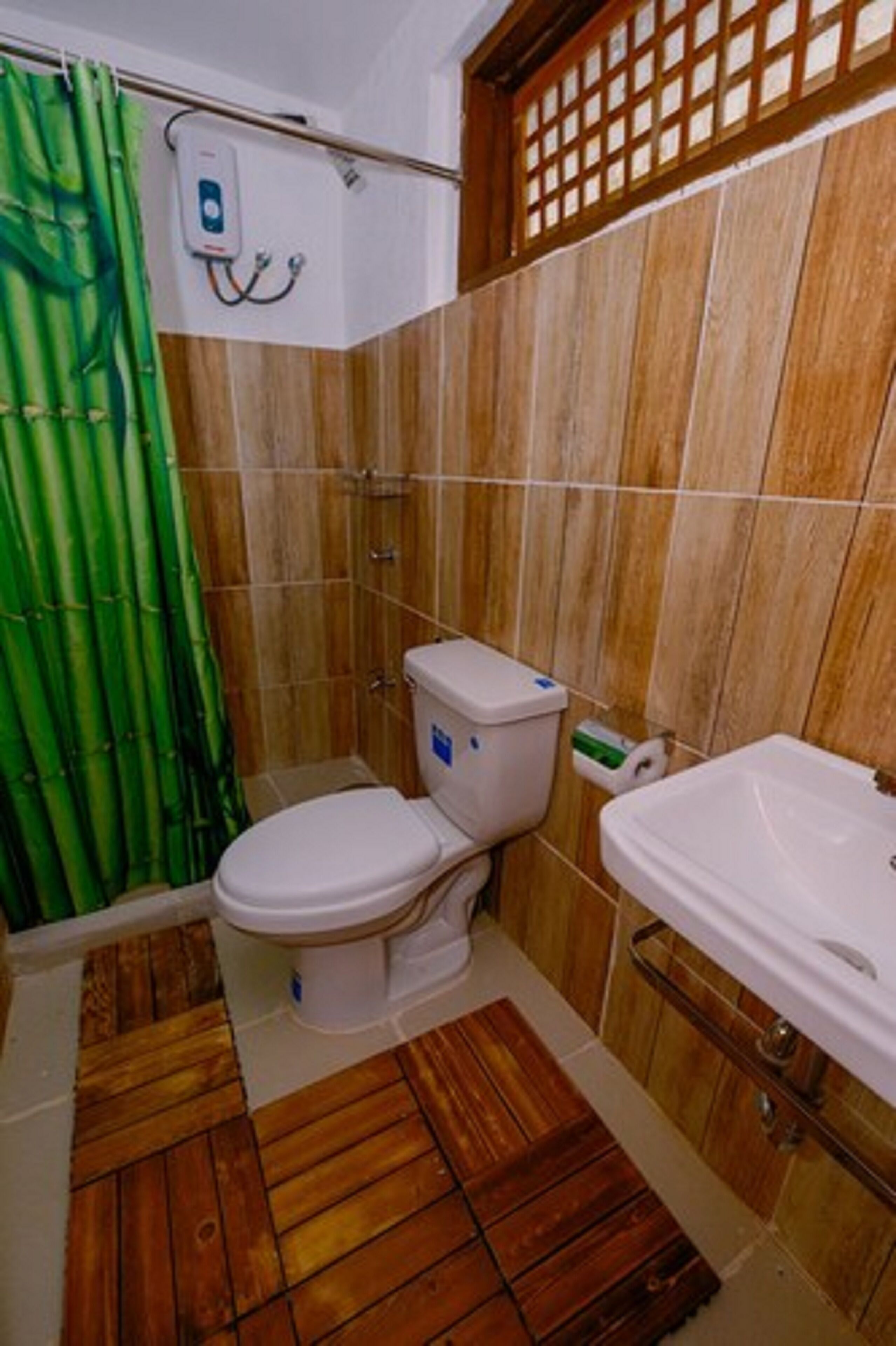 A bathroom with a toilet, sink, and shower curtain.