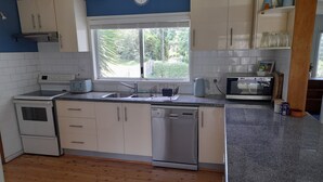 A kitchen with white cabinets, a stainless steel sink, a microwave, and a dishwasher.