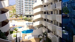 A hotel with multiple balconies, a pool area, and a view of a mountain. - Modern apartment close to the beach (Benalmádena)