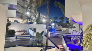 A modern hotel with multiple floors, outdoor terraces, and palm trees. - Modern apartment close to the beach (Benalmádena)