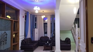 Amplia sala de estar con una lámpara moderna, una escalera y vistas de la ciudad.